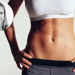 Frau mit straffem Bauch, die zeigt, wie bekommt man ein Sixpack durch Training und gesunde Ernährung.