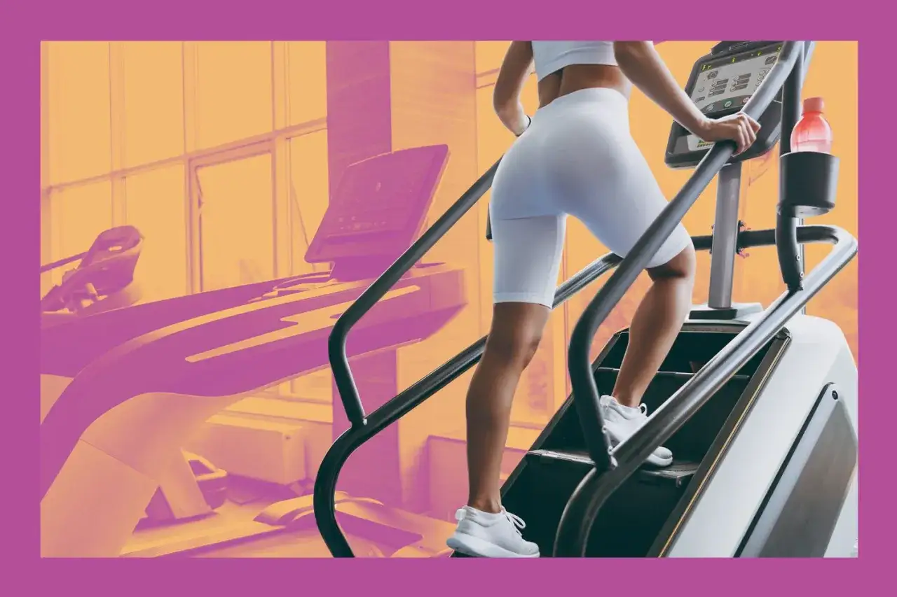 Frau steigt im Fitnessstudio auf einem Stairmaster. Was bringt Treppensteigen im Fitnessstudio? Es stärkt Beine und Po, verbessert die Ausdauer und verbrennt Kalorien.