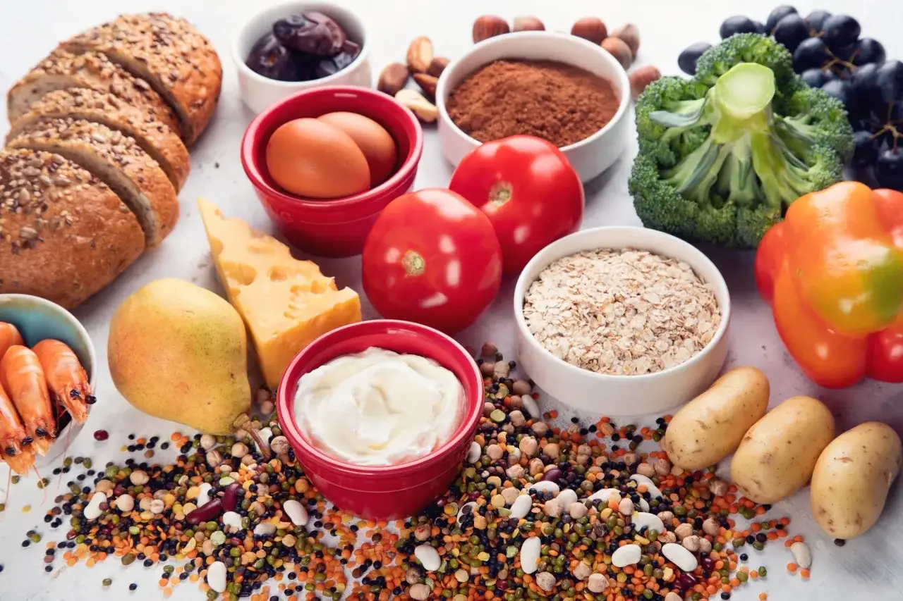Vielfalt an Lebensmitteln mit Chrom: Vollkornbrot, Eier, K&auml;se, H&uuml;lsenfr&uuml;chte, Beeren, Brokkoli, Paprika, Kartoffeln, Garnelen, Joghurt, Datteln, N&uuml;sse, Haferflocken.
