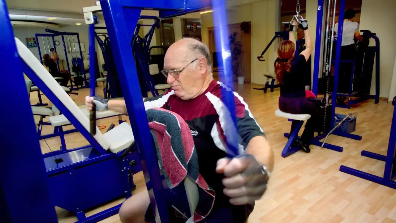 Ein Mann über 60 trainiert im Fitnessstudio. Muskelaufbau im Alter ist wichtig für seine Gesundheit und Vitalität.